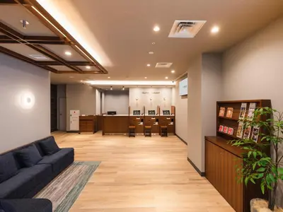 an office lobby with a waiting room with a couch at Sotetsu Fresa Inn Daimon in Tokyo