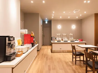 a restaurant with a counter with chairs and a table at Sotetsu Fresa Inn Daimon in Tokyo