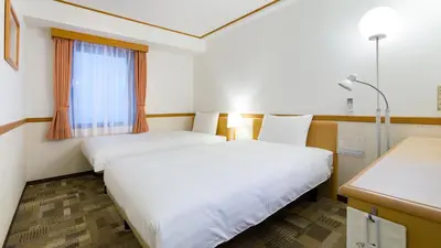 a hotel room with two beds and a window at Toyoko Inn Tokyo Tozai-sen Nishi-kasai in Tokyo