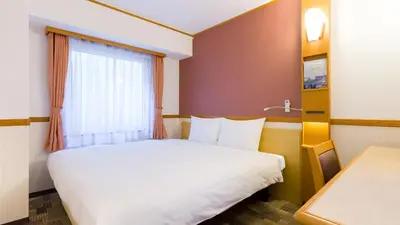 a hotel room with a bed and a window at Toyoko Inn Tokyo Shinagawa-eki Takanawa-guchi in Tokyo