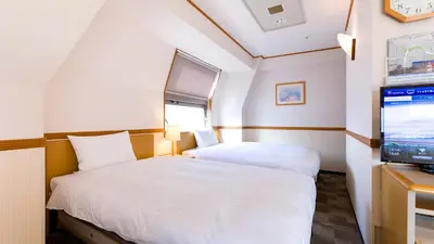 a bedroom with two beds and a flat screen tv at Toyoko Inn Tokyo Shinjuku Kabukicho in Tokyo
