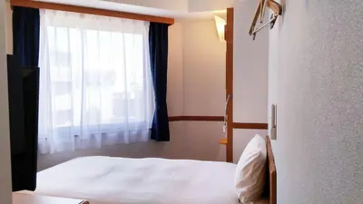 a bedroom with a white bed and a window at Toyoko Inn Tokyo Shinjuku Kabukicho in Tokyo