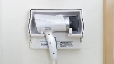a white paper towel dispenser on a wall at Toyoko Inn Tokyo Shinjuku Kabukicho in Tokyo