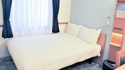 a white bed in a room with a window at Toyoko Inn Tokyo Korakuen Bunkyokuyakusho Mae in Tokyo
