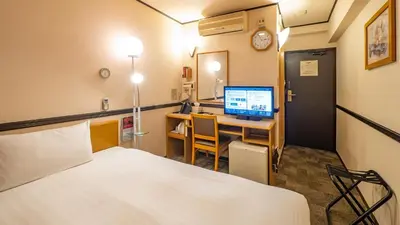 a room with a bed and a desk with a computer at Toyoko Inn Tokyo Asakusa Kuramae No 1 in Tokyo