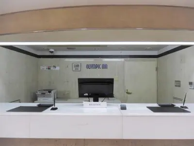 a reception desk with a computer on the wall at Olympic Inn Shibuya in Tokyo