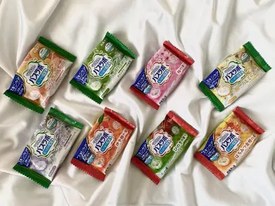 a group of four packets of chocolates on a bed at Olympic Inn Shibuya in Tokyo