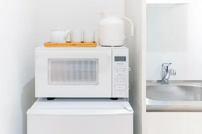 a microwave oven with cups on top of it in a kitchen at STone Hotel in Tokyo