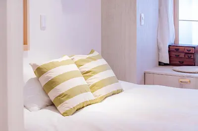 a bed with two yellow and white pillows on it at STone Hotel in Tokyo