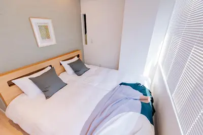 a bedroom with a bed with two pillows at STone Hotel in Tokyo