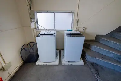 two refrigerators are sitting in a room with stairs at STone Hotel in Tokyo