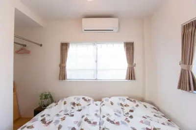 a bedroom with a bed and a window at &y Kitasenju in Tokyo