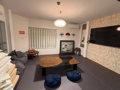 a living room with a couch and a table at &y Kitasenju in Tokyo