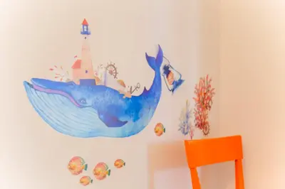 a mural of a whale and a lighthouse on a wall at &y Kitasenju in Tokyo