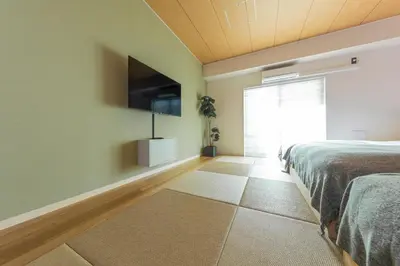 a bedroom with a bed and a flat screen tv at Goodsite In Oshiage in Tokyo