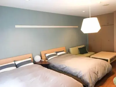 a bedroom with two beds and a pendant light at Goodsite In Oshiage in Tokyo