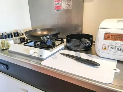 a kitchen counter with a frying pan on a stove at Goodsite In Oshiage in Tokyo