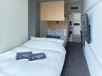 two beds in a hotel room with towels on them at Sakura Cross Hotel Ueno Iriya Annex in Tokyo