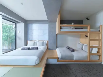 a bedroom with two beds and a book shelf at Sakura Cross Hotel Ueno Iriya Annex in Tokyo