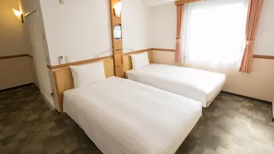 two beds in a room with a window at Toyoko Inn Tokyo Akabane-eki Higashi-guchi Ichiban-gai in Tokyo