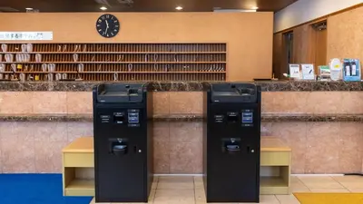 two parking meters in a library with a clock at Toyoko Inn Tokyo Monzen-nakacho Eitaibashi in Tokyo