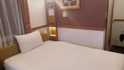 a small room with a white bed in it at Toyoko Inn Tokyo Uguisudani Ekimae in Tokyo