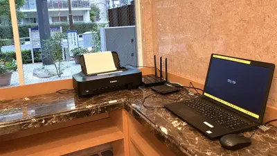 a desk with a laptop computer and a printer at Toyoko Inn Tokyo Shinagawa Oimachi in Tokyo