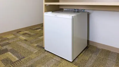 a small white refrigerator sitting under a counter at Toyoko Inn Nihombashi Bakurocho in Tokyo