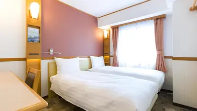 a hotel room with two beds and a window at Toyoko Inn Nihombashi Bakurocho in Tokyo