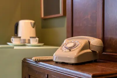 a beige phone sitting on top of a wooden cabinet at Shinjuku ICE MOUNTAIN GUEST HOUSE in Tokyo