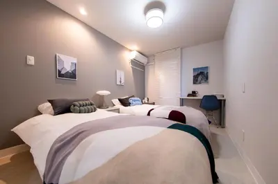 a bedroom with two beds and a window at Shinjuku ICE MOUNTAIN GUEST HOUSE in Tokyo