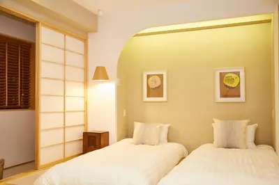 two beds sitting next to each other in a bedroom at Asakusa New City Hotel in Tokyo