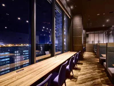 a long wooden table in a restaurant with chairs at LOISIR HOTEL SHINAGAWA SEASIDE in Tokyo