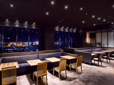 a restaurant with tables and chairs and a view of the city at LOISIR HOTEL SHINAGAWA SEASIDE in Tokyo