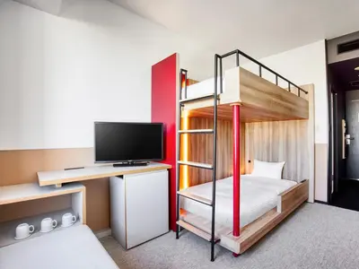 a bedroom with a bunk bed with a desk and a television at LOISIR HOTEL SHINAGAWA SEASIDE in Tokyo