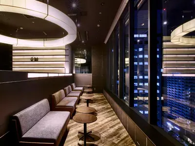 a bar with couches and tables and a window at LOISIR HOTEL SHINAGAWA SEASIDE in Tokyo
