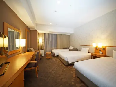 a hotel room with two beds and a desk at LOISIR HOTEL SHINAGAWA SEASIDE in Tokyo