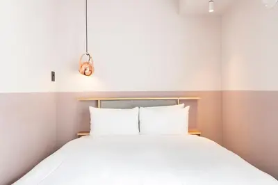 a bedroom with a white bed with white pillows at Hotel Asakusa KANNONURA in Tokyo