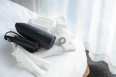 a black hair dryer sitting on top of a bed at Hotel Asakusa KANNONURA in Tokyo