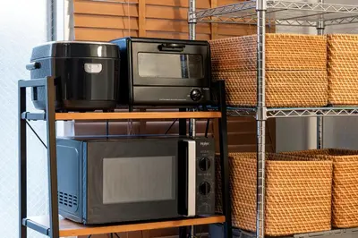 a television and a microwave on a shelf at Hotel Asakusa KANNONURA in Tokyo