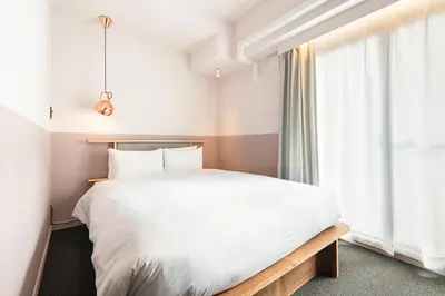 a bedroom with a white bed and a window at Hotel Asakusa KANNONURA in Tokyo