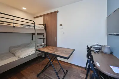 a room with a desk and a bunk bed at Stylewood Nishi-Shinjuku by Tranova in Tokyo