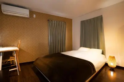 a small bedroom with a bed and a window at Apartment Sunbright in Tokyo