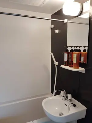 a bathroom with a white sink and a mirror at Apartment Sunbright in Tokyo