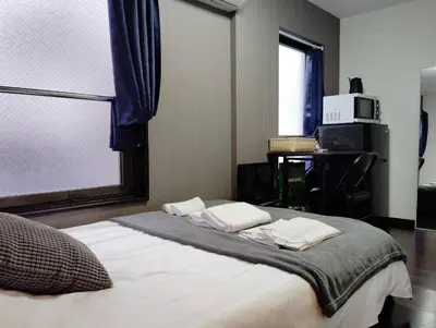 a bedroom with a bed with pillows and a window at Apartment Sunbright in Tokyo