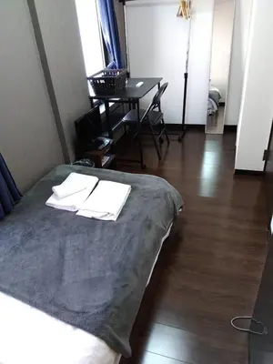 a room with a bed with a table and a tableablish at Apartment Sunbright in Tokyo