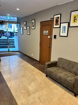 a living room with a couch and a door at Apartment Sunbright in Tokyo