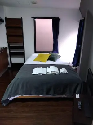 a bedroom with a bed with two towels on it at Apartment Sunbright in Tokyo