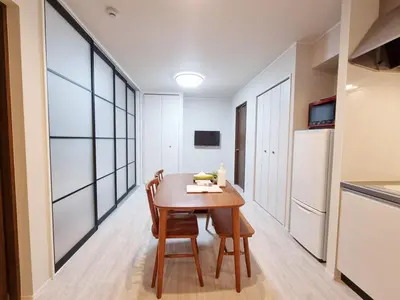 a dining room with a table and a refrigerator at PRISM Inn Kamata in Tokyo