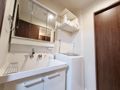 a white bathroom with a sink and a refrigerator at PRISM Inn Kamata in Tokyo